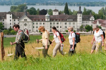 Pilgergruppe auf einer Anhöhe über dem Kloster Hegne