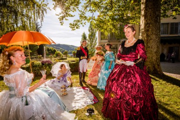 Kostümgruppe beim Picknick im Park