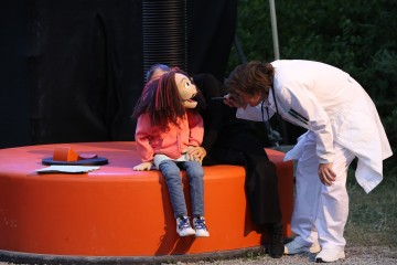 Simon Engeli, in einer seiner vielen Rollen, interagiert mit Puppe Tilda